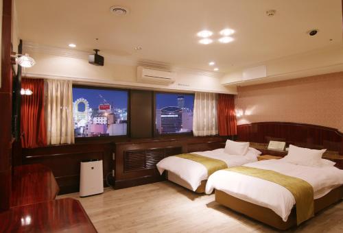 una camera d'albergo con due letti e una televisione di Hotel Alps ad Osaka