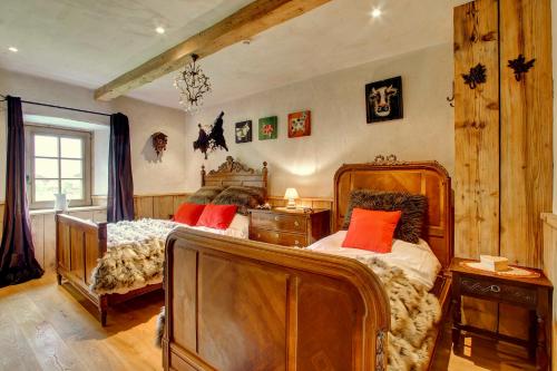 a bedroom with two beds with red pillows at La Ferme du Lac Vert in Montriond
