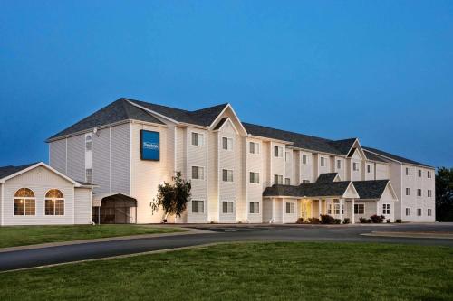 a large white building with a blue sign on it at Travelodge by Wyndham Fort Scott in Fort Scott