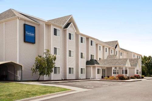 a large white building with a blue sign on it at Travelodge by Wyndham Fort Scott in Fort Scott
