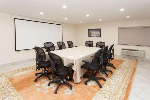 a conference room with a white table and black chairs at Baymont by Wyndham Chicago/Alsip in Alsip