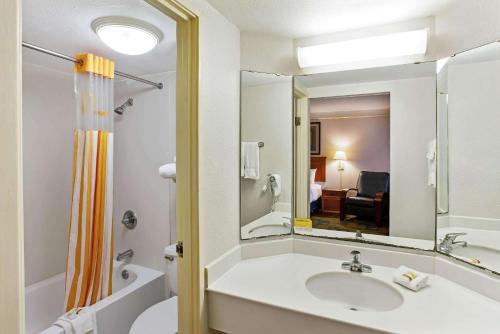 a bathroom with a sink and a mirror at La Quinta Inn by Wyndham College Station in College Station