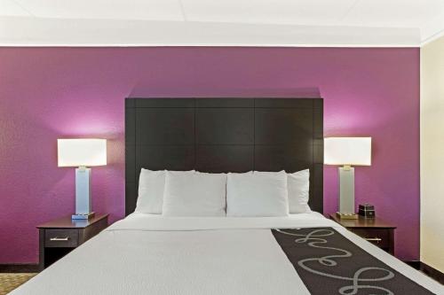 a bedroom with a large bed with purple walls at La Quinta by Wyndham Boston-Andover in Andover