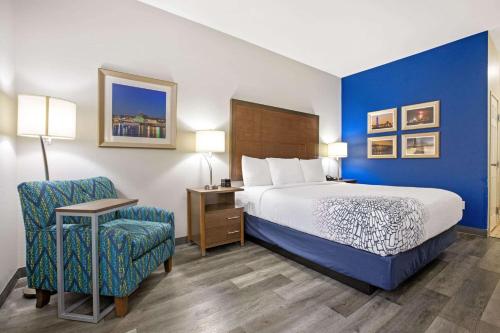 a hotel room with a bed and a chair at La Quinta by Wyndham NE Long Beach/Cypress in Hawaiian Gardens