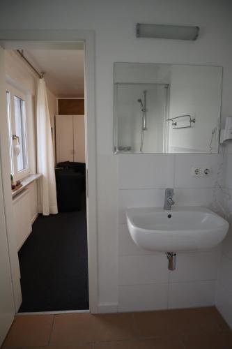a bathroom with a sink and a mirror on the wall at Rheinblick Hattenheim Boutique Art Gästehaus in Hattenheim