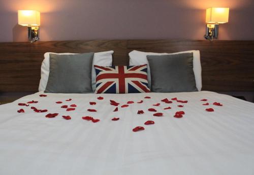 a bed with a white and red comforter and pillows at Sheriff Hotel in London