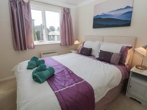 una camera con un grande letto e una finestra di Cumbria Court a Windermere
