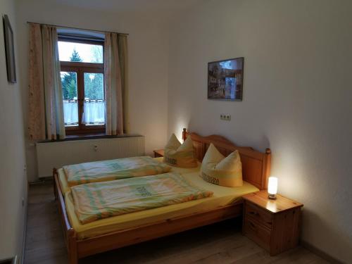 1 dormitorio con 1 cama y 1 vela sobre una mesa en Ferienwohnung "Zur Kleinbahn", en Zittau