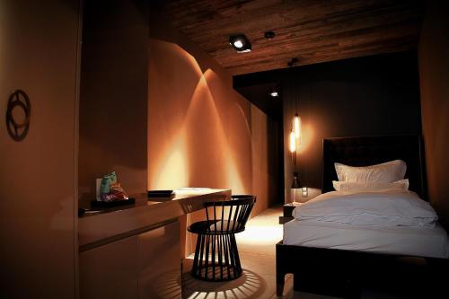a bedroom with a bed and a desk with a chair at Hotel Zhero – Ischgl/Kappl in Kappl