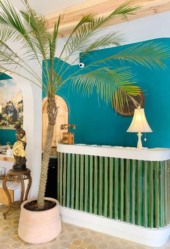a palm tree in a room with a blue wall at Lacasa May in Da Lat