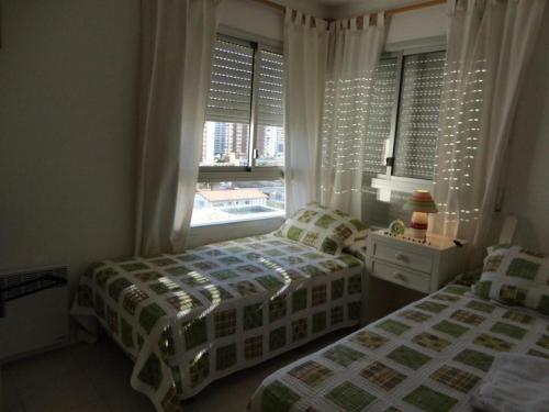 1 Schlafzimmer mit 2 Einzelbetten und einem Fenster in der Unterkunft Long Beach - casi un spa in Punta del Este