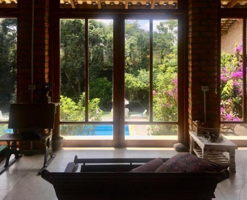 a living room with a couch and a large window at Toca da Capuava in Cotia