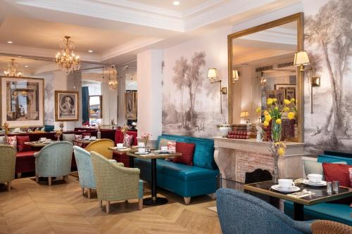 un restaurant avec des tables et des chaises et une cheminée dans l'établissement Odeon Hotel, à Paris