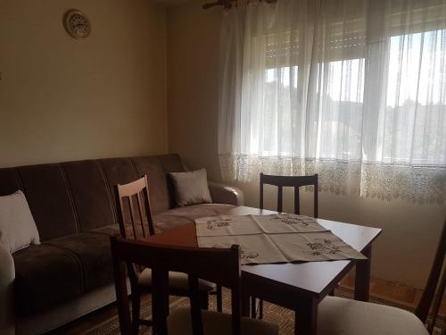 een woonkamer met een tafel en stoelen en een bank bij Vila Happy Story in Knjazevac.