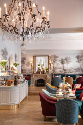 een eetkamer met een kroonluchter en een tafel bij Odeon Hotel in Parijs