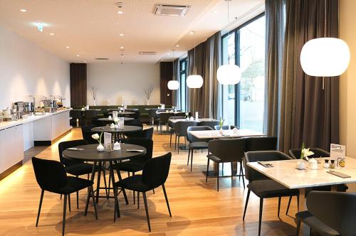 a restaurant with tables and chairs and a counter at GINN City and Lounge Ravensburg in Ravensburg
