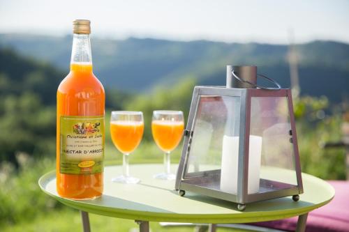 Una botella de cerveza y dos vasos en una mesa. en L'Echappée Trémoussante, en Saint-Barthélemy-de-Vals