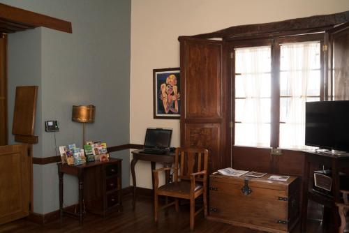 a living room with a desk and a television at Hotel Boutique La Posada in Sucre