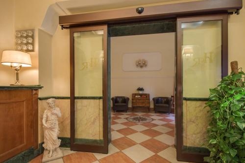 een lobby met een glazen deur met een standbeeld erin bij Hotel RomAntica in Rome