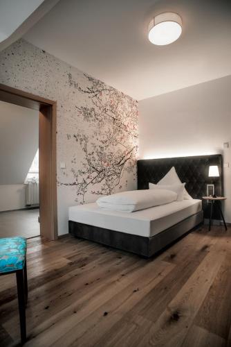 a bedroom with a bed and a wall with flowers at Landhaus Hechtsberg in Hausach