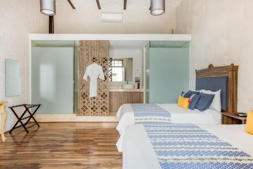 a bedroom with two beds and a bathroom at Milagro Hotel in Puebla