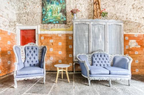 2 sillas azules y una mesa en una habitación en Milagro Hotel, en Puebla