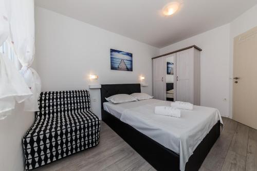 een slaapkamer met een bed en een stoel bij Villa Luana in Vis