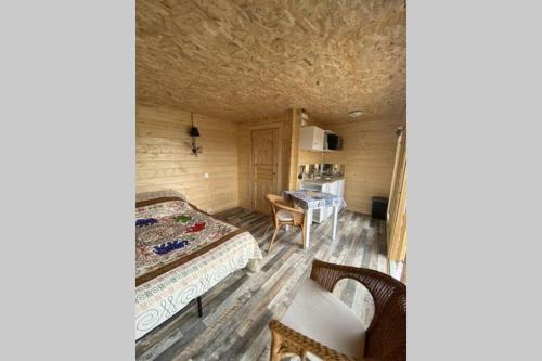 ein Schlafzimmer mit einem Bett und einem Tisch in einem Zimmer in der Unterkunft Charmant Chalet pour 2 personnes SPA privé in Massillargues-Attuech