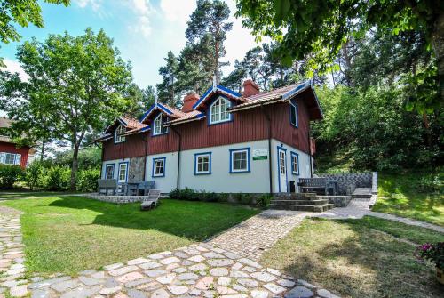 ein Haus mit rotem Dach in der Unterkunft Apartamentai Geliu Vila in Nida