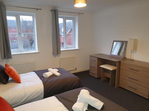 a bedroom with two beds and a desk and a television at Comfortable and Welcoming Beatrix House by Cliftonvalley Apartments in Bristol