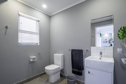 uma casa de banho branca com um WC e um lavatório em Inner Harbour Charm em Durban