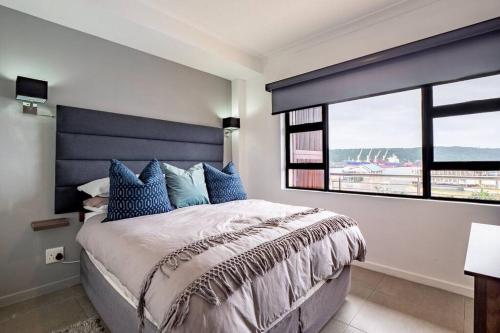 um quarto com uma cama grande e uma janela grande em Inner Harbour Charm em Durban