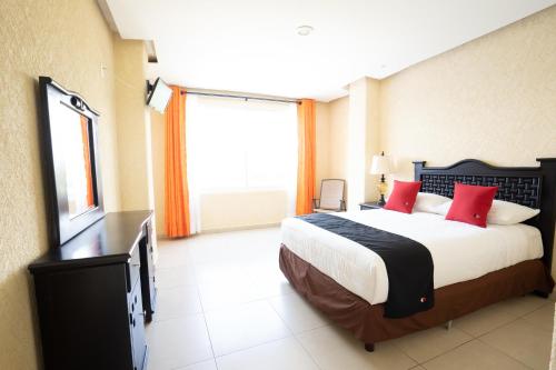a bedroom with a large bed and a large window at Capital O Hotel Los Caracoles, Acapulco in Acapulco