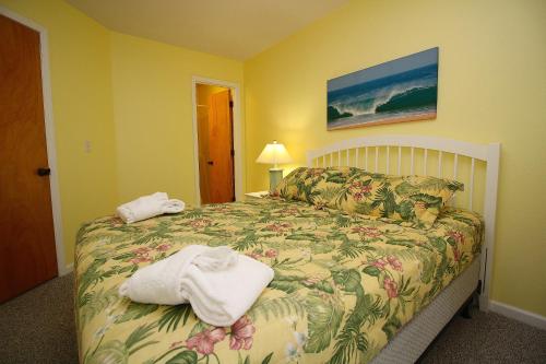 ein Schlafzimmer mit einem Bett mit Handtüchern darauf in der Unterkunft Station One by Kees Vacations in Kill Devil Hills
