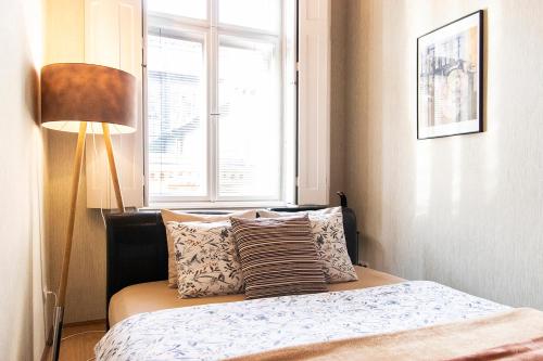 a bedroom with a bed with a lamp and a window at Pipa Apartment in Budapest