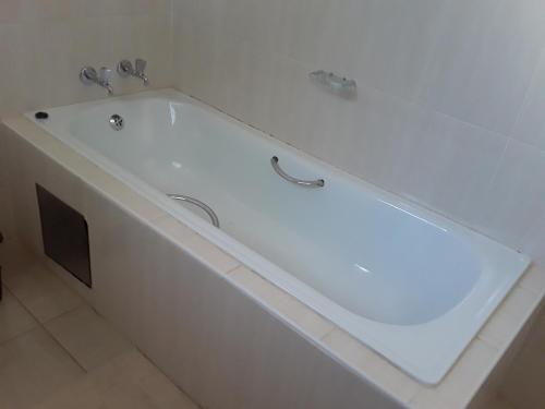 Serowe的住宿－Rest & Digest，浴室内设有大型白色浴缸。