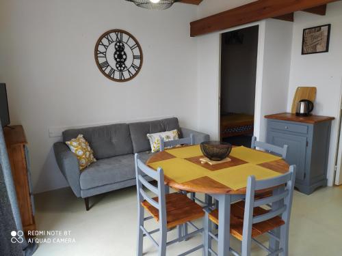 a living room with a table and a couch at Logement 88 2-4 Personnes 500 m plage classé 2 étoiles in Dolus d'Oléron