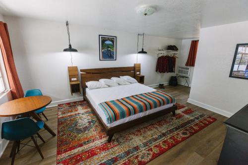 a bedroom with a bed and a table and a rug at Route 19 Inn in Maggie Valley