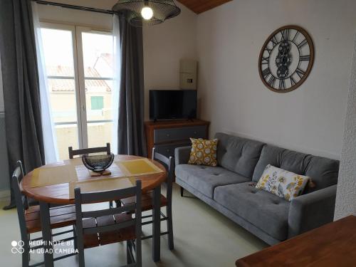 a living room with a couch and a table at Logement 88 2-4 Personnes 500 m plage classé 2 étoiles in Dolus d'Oléron