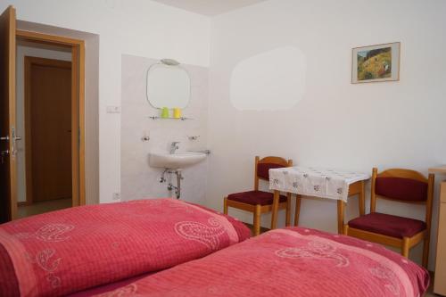 - une chambre avec un lit, un lavabo et une table dans l'établissement Appartment Felder Erika, à Valdaora
