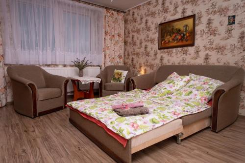 a bedroom with a bed and two chairs at Agroturystyka Gawryś apartament in Sasino