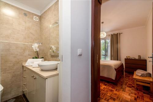 a bathroom with a sink and a bedroom at Senna Apartment in Lisbon