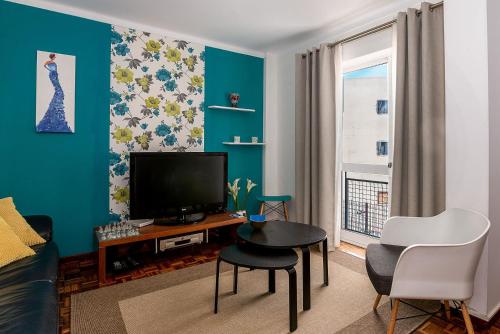 a living room with a television and a table and chairs at Senna Apartment in Lisbon