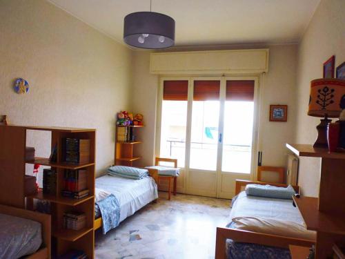 - une chambre avec 2 lits et une grande fenêtre dans l'établissement Ampio alloggio molto confortevole, 7 posti letto, à Spotorno