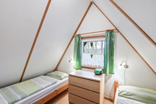 um quarto com uma cama e uma janela com cortinas verdes em Ferienhaus Marpe 100 em Bad Arolsen