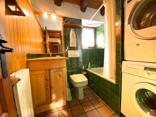 een badkamer met een toilet, een wastafel en een wasmachine bij C5 Bordes d'Arinsal, Duplex Rustico con chimenea, Arinsal, zona vallnord in Mas de Ribafeta