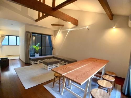 a living room with a wooden table and chairs at ＡＴＴＡ ＨＯＴＥＬ ＫＡＭＡＫＵＲＡ / Vacation STAY 76820 in Kamakura