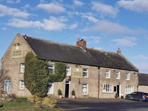 an old brick building with ivy growing on it at The Manor House Inn in Shotley Bridge