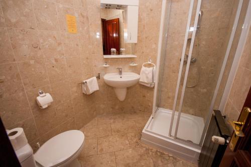 a bathroom with a toilet and a sink and a shower at Korona Pension and Restaurant in Hévíz