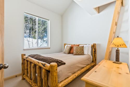 a bedroom with a wooden bed with a window at Schweitzer Ullr Retreat in Sandpoint